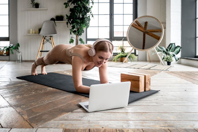 Woman doing sports exercises online workout home