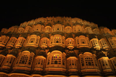 Low angle view of illuminated building against sky at night