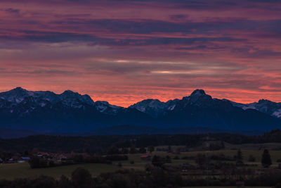 Scenic view of snowcapped mountains against sky at sunset