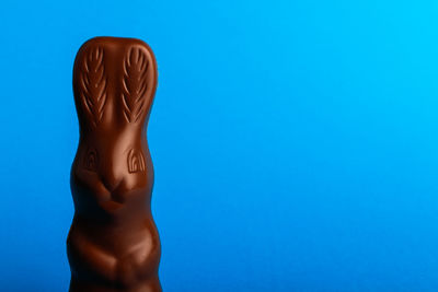 Rear view of shirtless man against blue background