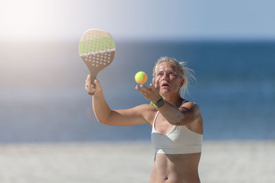 Full length of woman with ball on beach