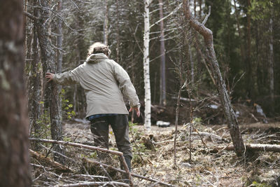 Rear view of man standing in forest