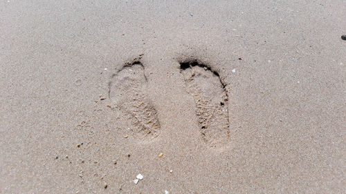 High angle view of footprints on sand