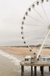 Ferris wheel at beach against sky