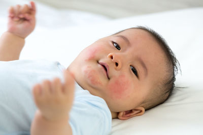 Portrait of cute boy lying on bed