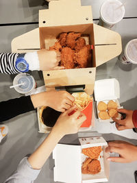 High angle view of woman holding food on table