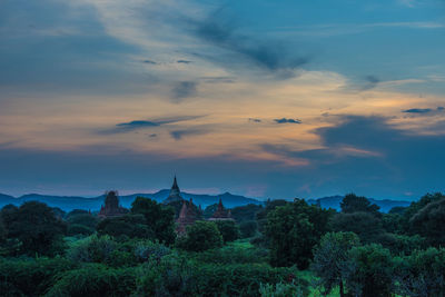 Pagoda amongst trees against dramatic sky