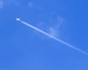 Low angle view of vapor trail against blue sky