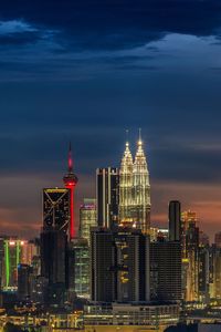 Illuminated buildings in city against sky