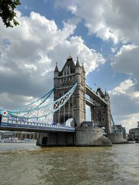 View of bridge over river against cloudy sky