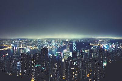 Illuminated cityscape against sky at night