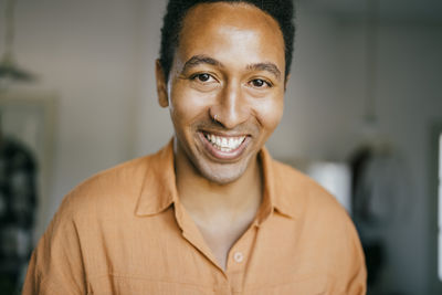 Portrait of smiling man with nose ring at home