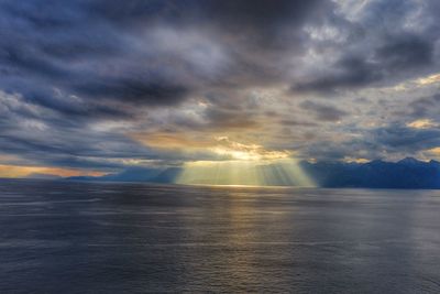 Scenic view of sea against dramatic sky during sunset