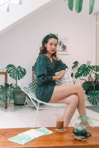 Portrait of woman sitting on table at home