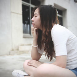 Midsection of woman sitting outdoors