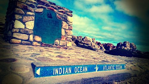 Information sign on rock against blue sky