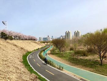 Road leading towards city against sky