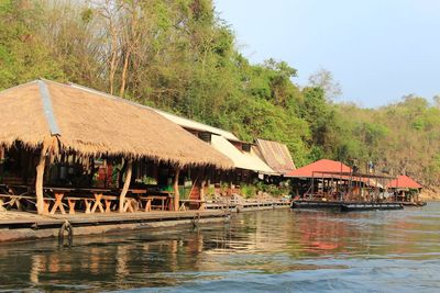Houses by river against sky