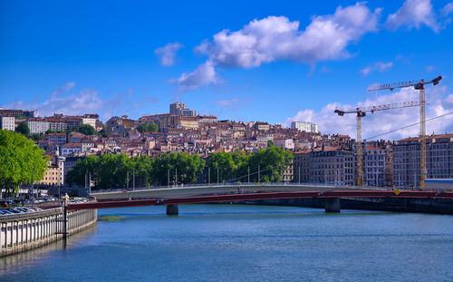 Bridge over river against buildings in city