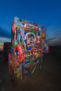 Graffiti on wall by sea against sky