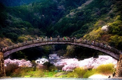 People walking on bridge over river