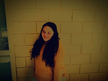 Portrait of woman standing against wall