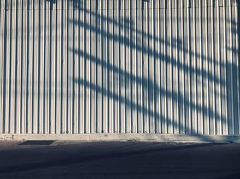 Shadow of metal fence on footpath