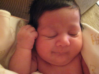 Close-up of baby sleeping in bed