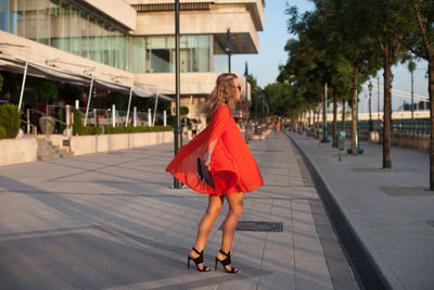 Portrait of young woman walking on street in city