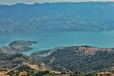 Scenic view of sea by mountains against sky