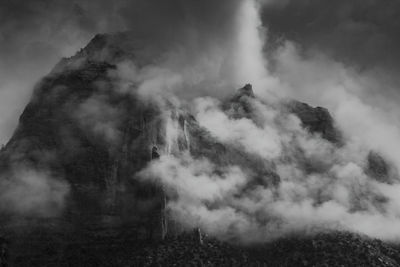 Smoke emitting from volcanic mountain against sky