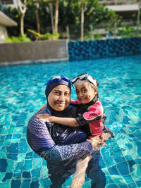 Portrait of young woman swimming in pool