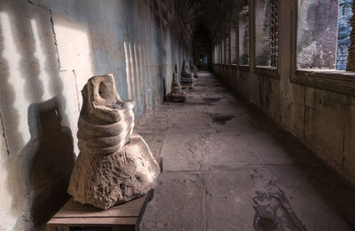 Buddha head broken sitting in angkor wat temple, siem reap cambodia.