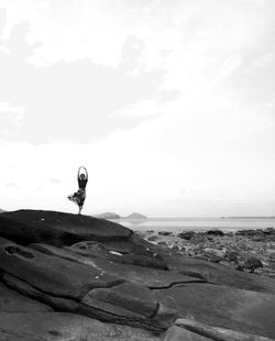 Scenic view of rocks by sea against sky