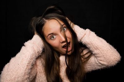 Portrait of girl messing around against black background