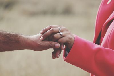 Midsection of couple holding hands