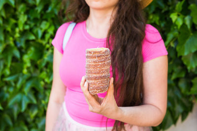 Midsection of woman holding pink food