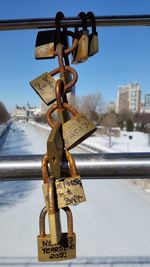 Close-up of padlocks hanging on railing against sky