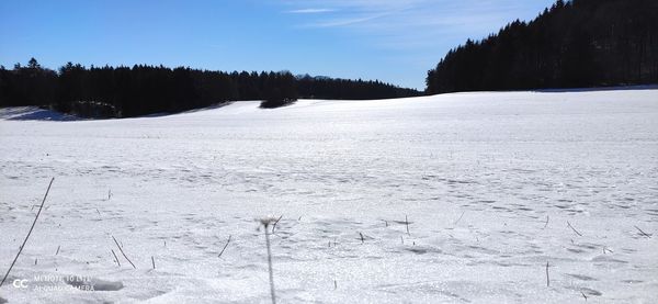 Scenic view of snow covered field against sky