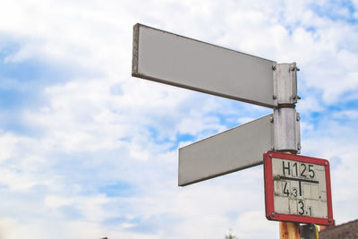 Low angle view of road sign against sky