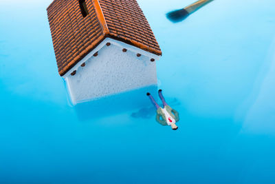 High angle view of figurine with house in water