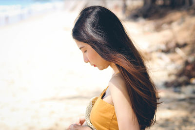 Woman looking down while standing at beach