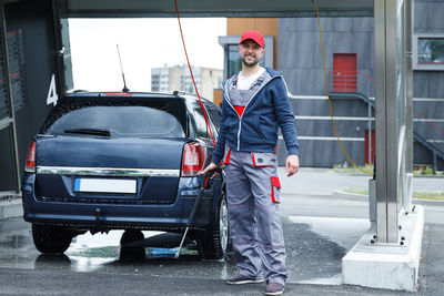 Portrait of man standing in car