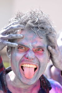 Close-up portrait of man covered in powder paint during holi