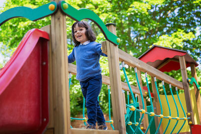Portrait of smiling young woman standing against plants