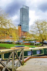 Buildings by swimming pool in park against sky