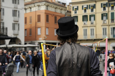 Rear view of people standing on street in city