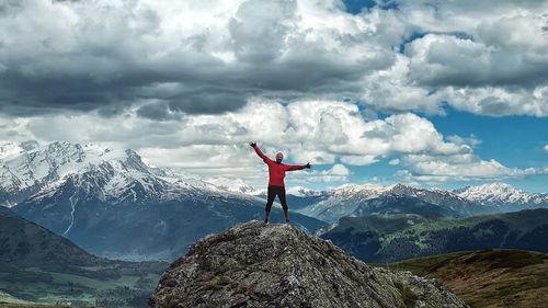 Full length of man standing on snowcapped mountain against sky