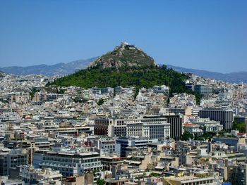 Aerial view of cityscape against clear blue sky