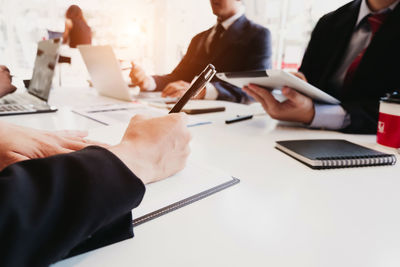 Midsection of man using laptop on table